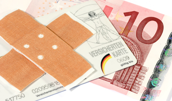 Ein großes Pflaster auf einer Versichertenkarte und darunter ein 10 Euro Geldschein 